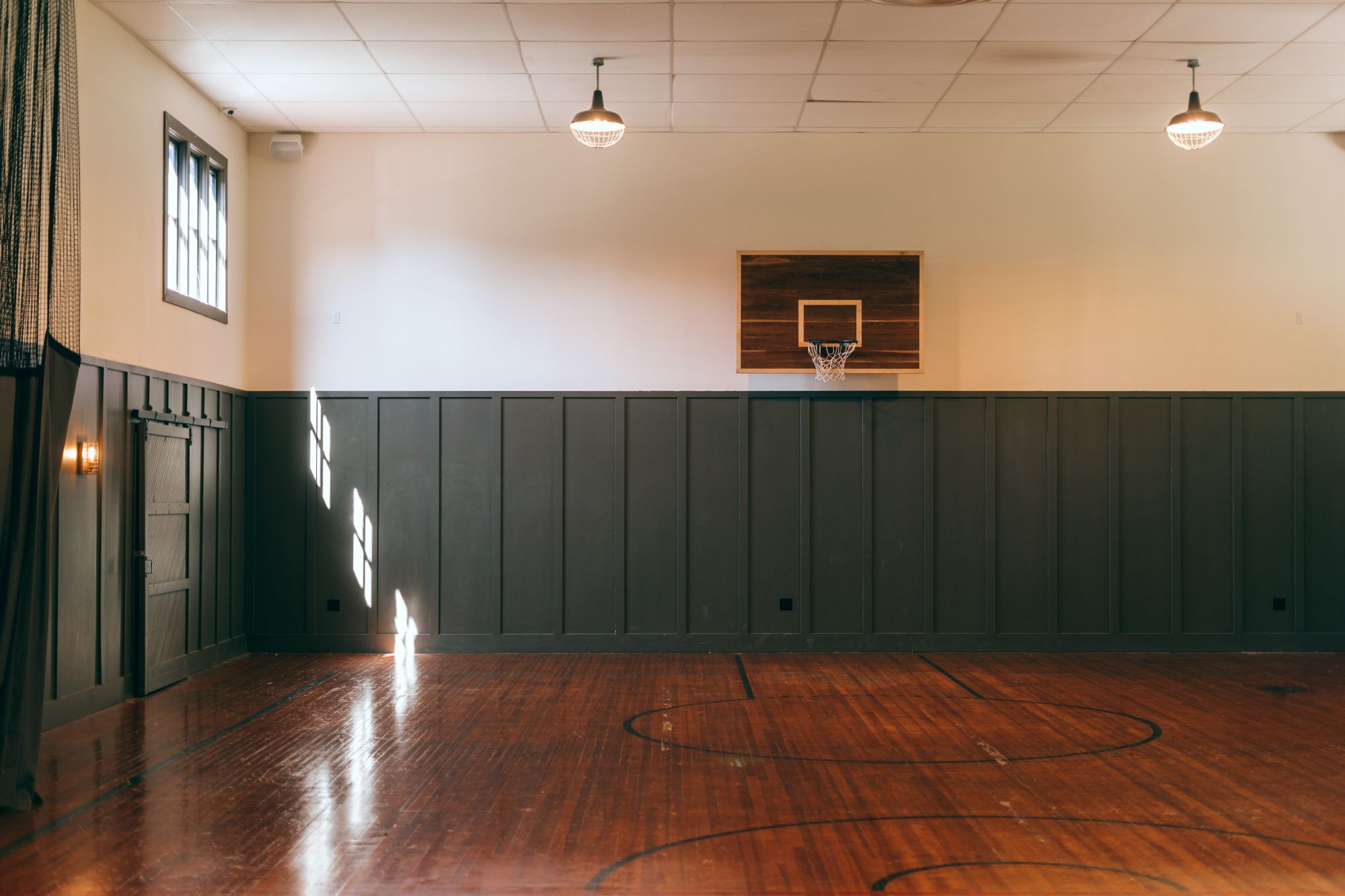 Empty basketball gym with a single hoop